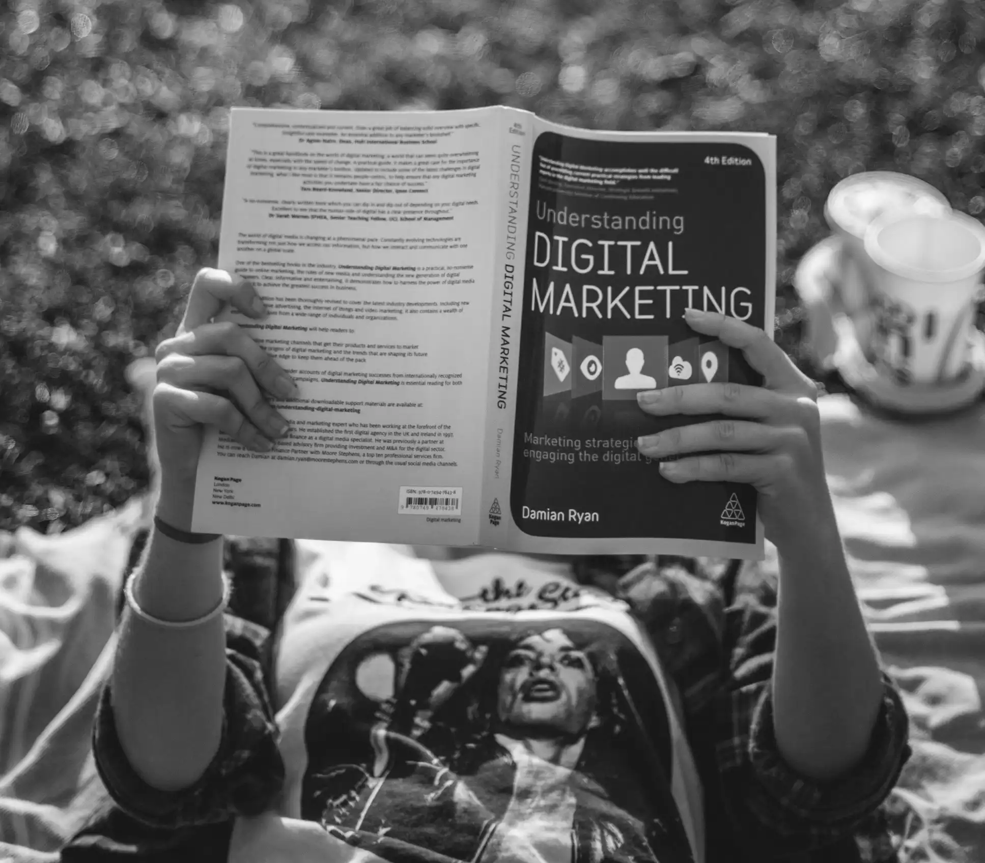A black and white image of a person reading a book, digital marketing strategist in kochi