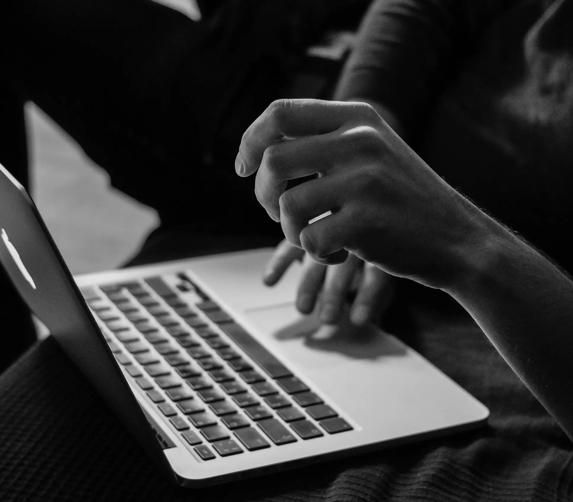 Black and white image of a digital marketing strategist in kochi working on a laptop